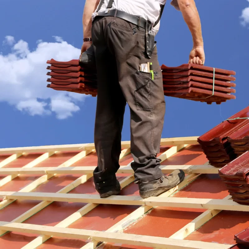 Artisan couvreur en pleine pose de charpente et couverture